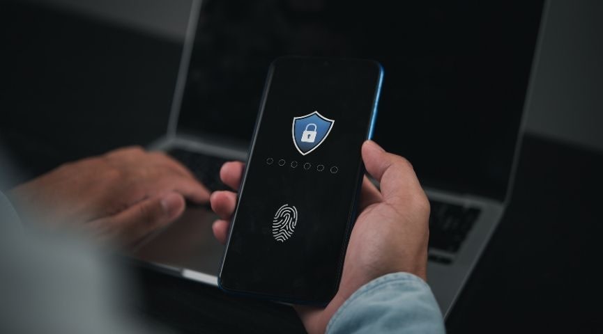A person holding a mobile phone with a lock and fingerprint displayed on the black screen.